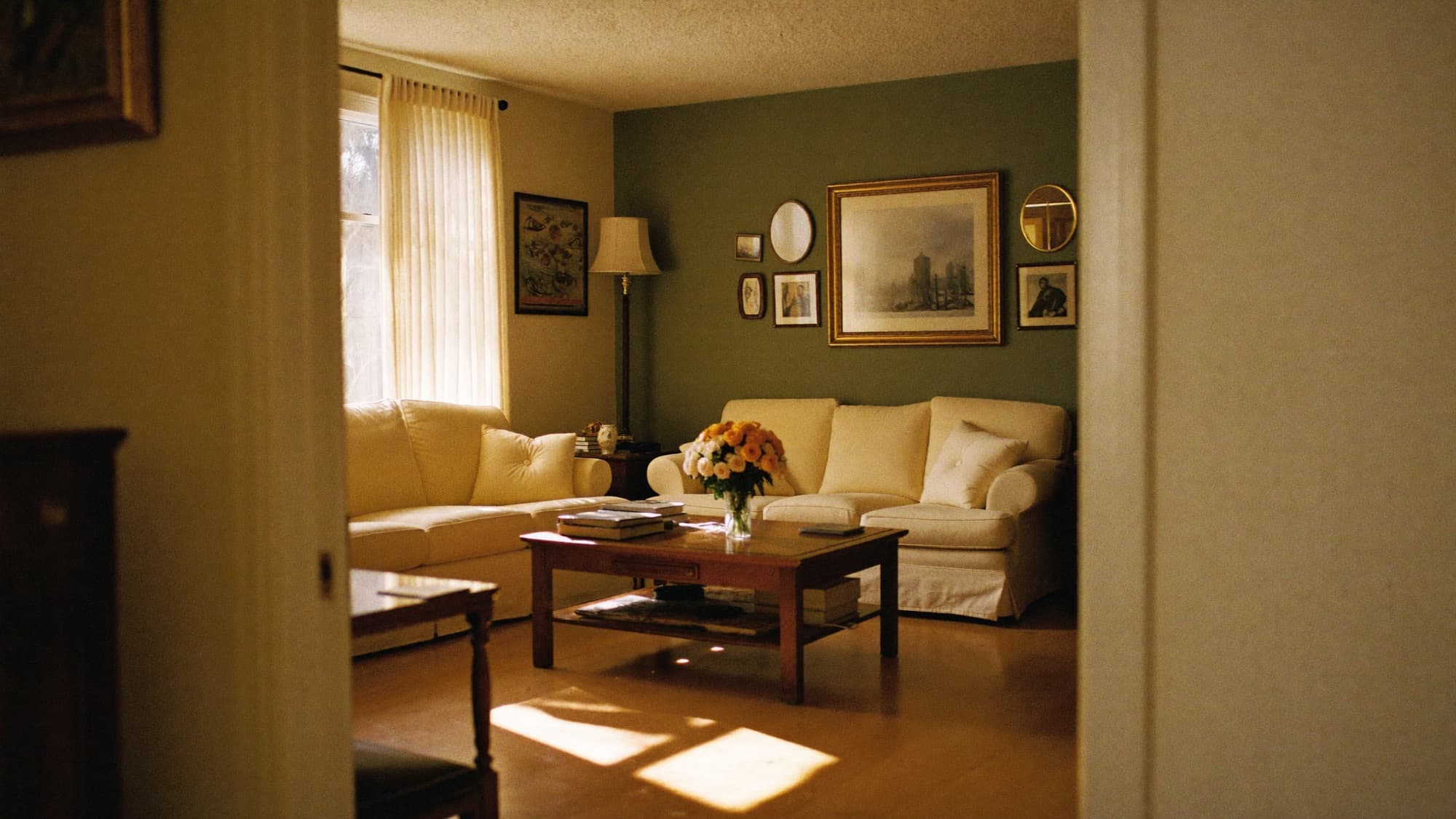 A sunlit living room at Valrico Family Care Home, with cream sofas and a soft sage-green accent wall